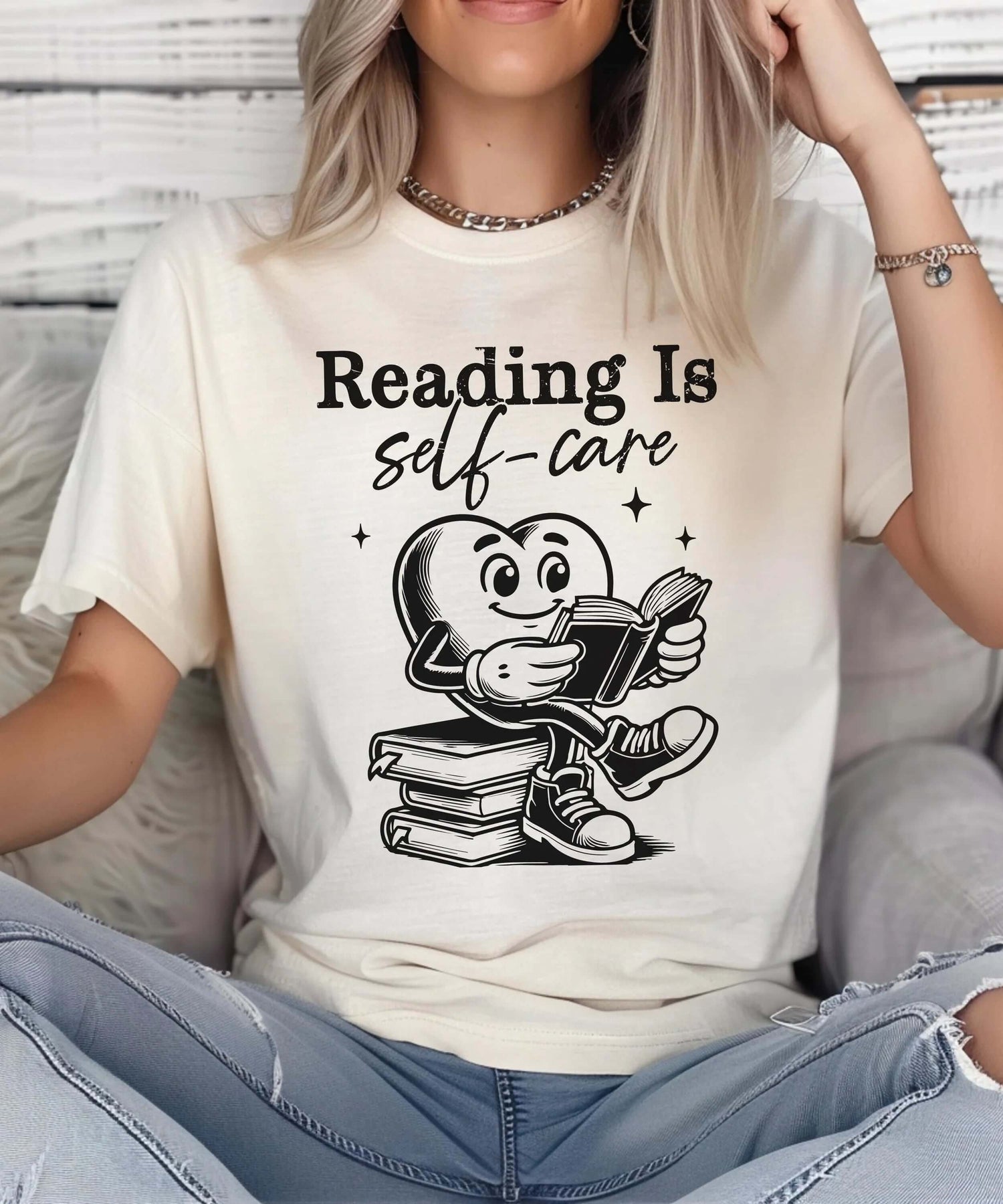 Person wearing a shirt that says 'Reading Is self-care' surrounded by books, promoting the idea of School.