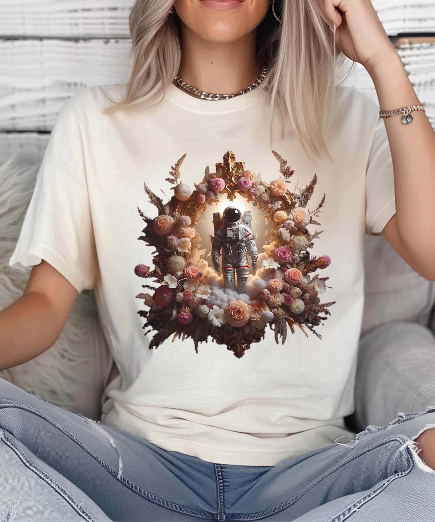 Woman wearing a cream t-shirt featuring a popular astronaut and floral design.